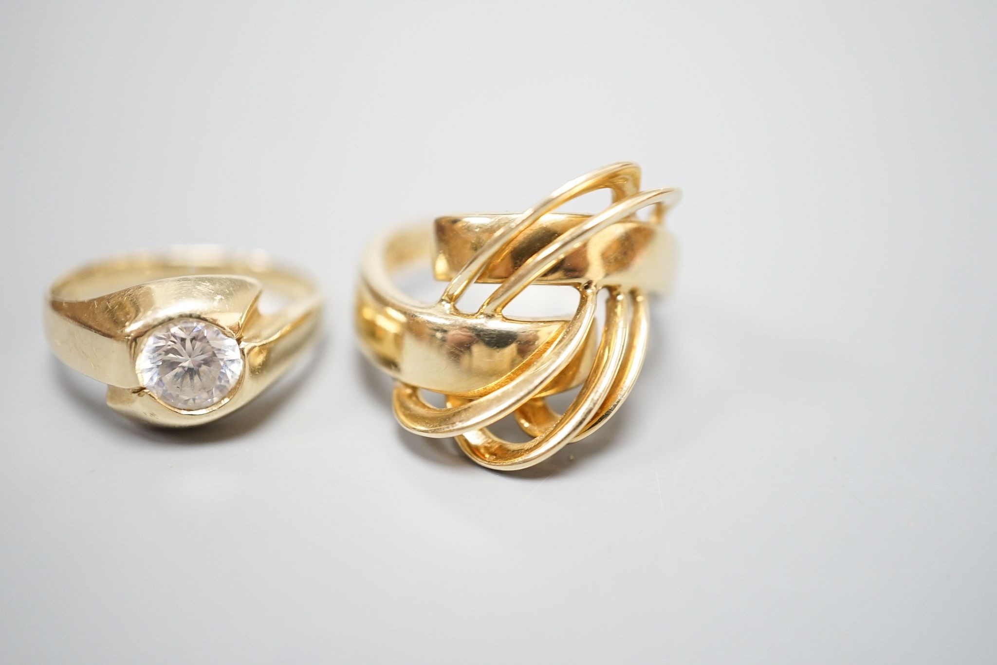 An Italian 750 scroll ring, size P, 5.5 grams and a 585 and white stone ring, gross 3.9 grams.